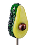 Close up of Avocado Poker by Empire Glassworks, that is an avocado cut in half, exposing the avocado seed.